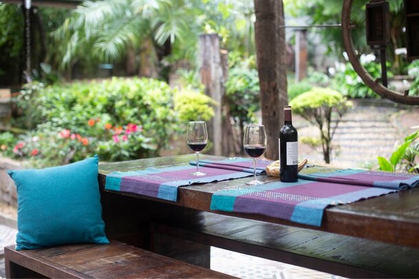 A table set with two wine glasses on a blue and purple placemat, creating an elegant dining atmosphere.