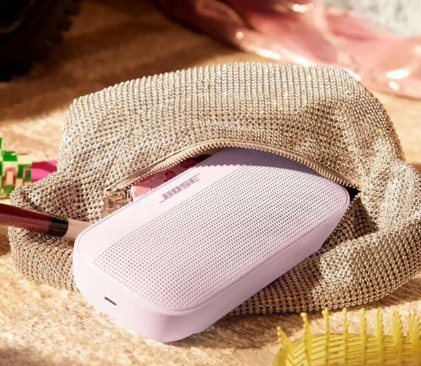 A pink purse containing a phone and various items, showcasing a stylish and organized accessory.
