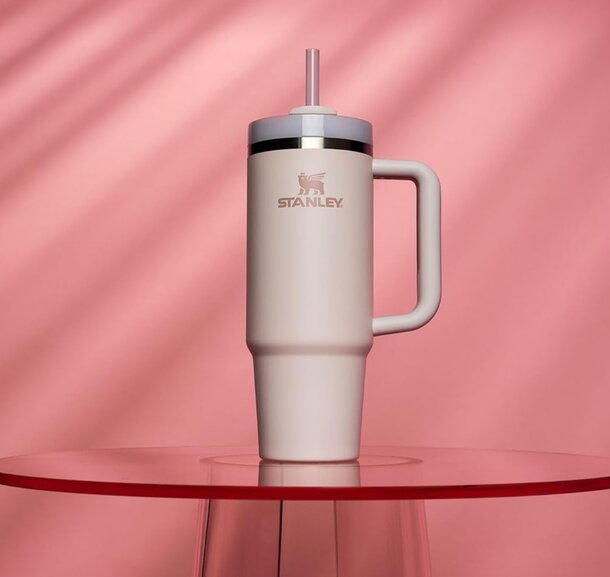 A white tumbler with a straw, resting on a flat surface, ideal for beverages.
