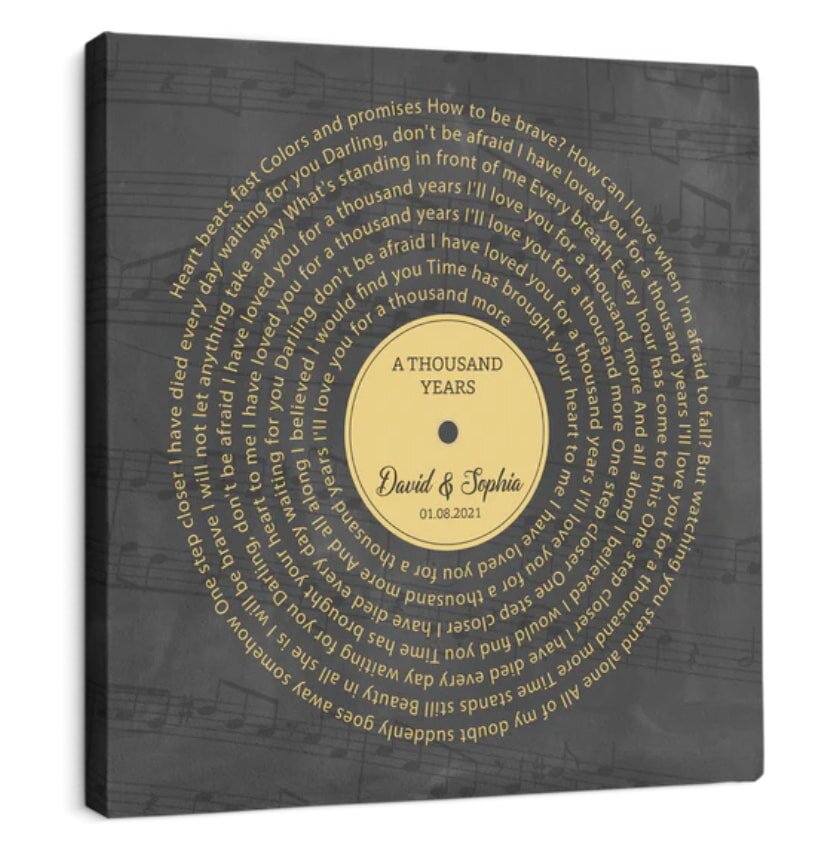 Canvas artwork featuring a vinyl record design with the text "A Thousand Years" in the center. Lyrics surround it in a circular pattern against a musical score background.