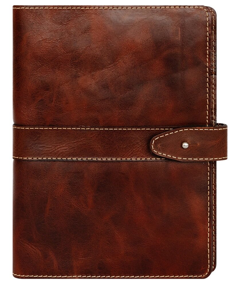 A brown leather notebook with a textured cover, closed and resting on a wooden surface.