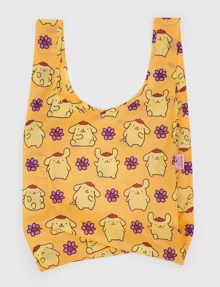 Yellow tote bag with cute cartoon dogs and purple flowers pattern on a plain background.