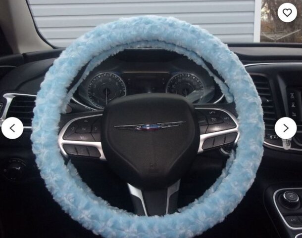 A steering wheel cover featuring a blue fuzzy pattern with stars, adding a cozy touch to vehicle interiors.