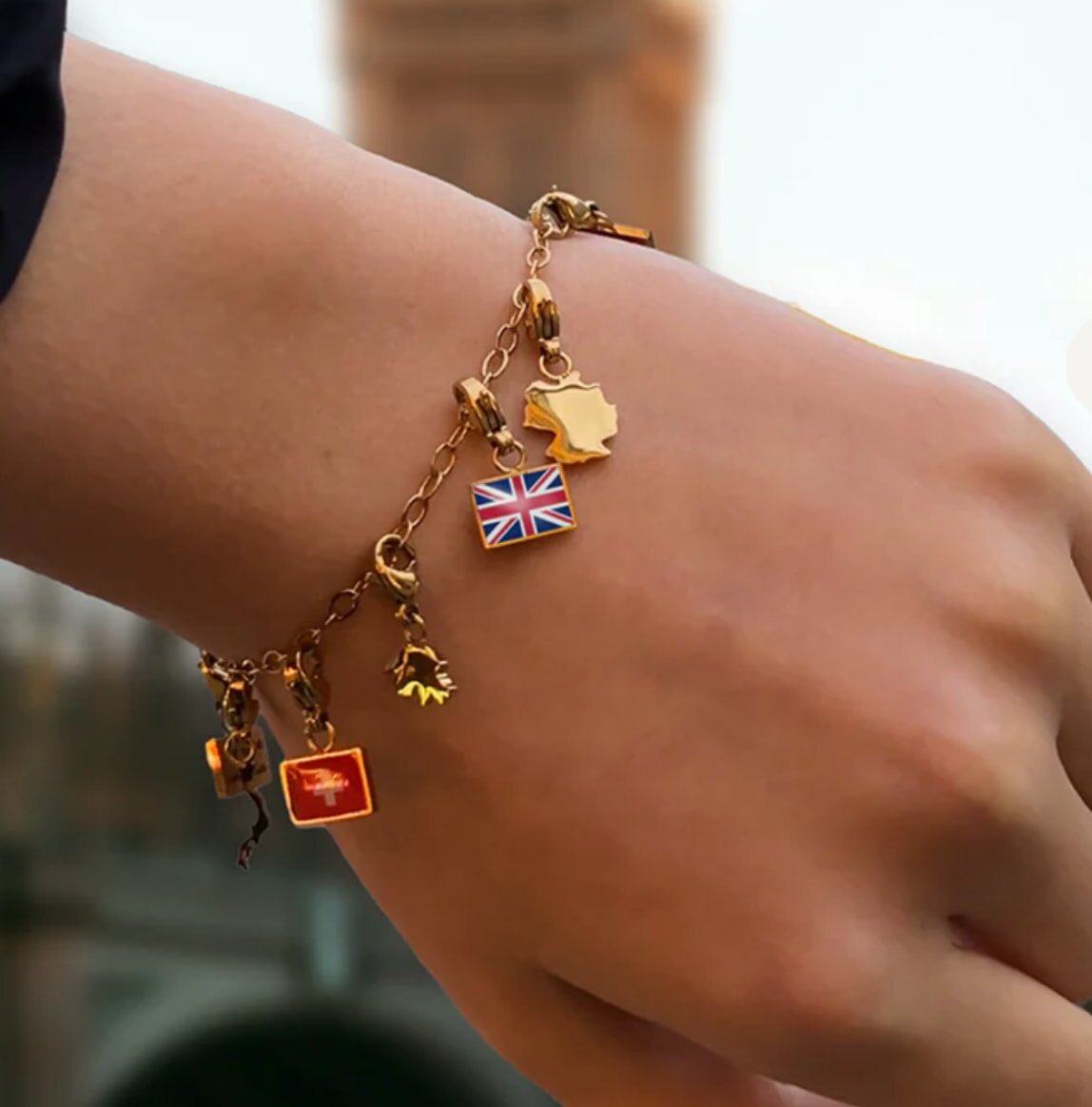 A woman displays a bracelet featuring a British flag and a heart design, symbolizing patriotism and love.