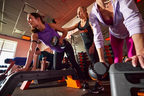 A group of women lifting weights in a gym, showcasing strength and teamwork during their workout session.