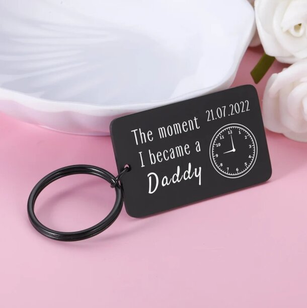 Personalised keyring inscribed with "The moment I became a daddy," celebrating fatherhood and cherished memories.