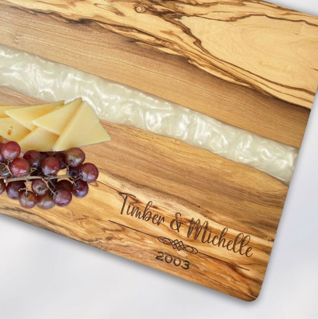 A personalized cheese board featuring an assortment of cheeses and fresh grapes arranged artfully.