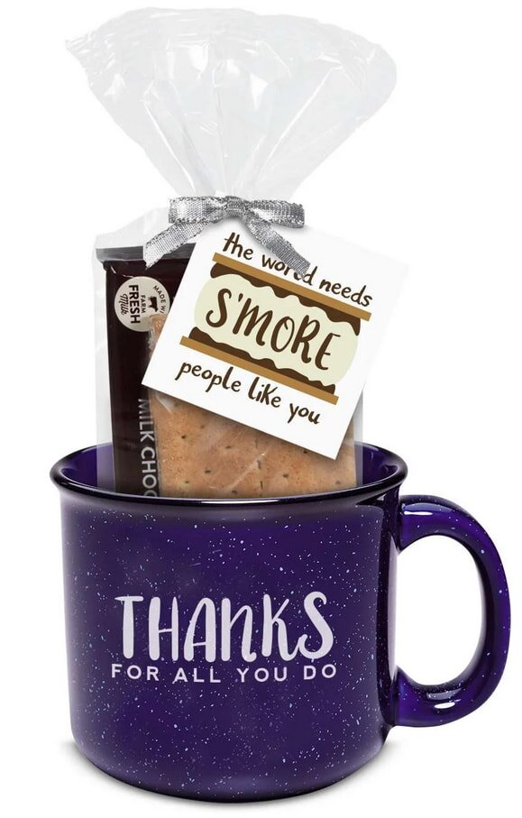 A purple speckled mug with the text "Thanks for all you do" holds a s'mores kit. A note, "The world needs s'more people like you," adds a grateful touch.