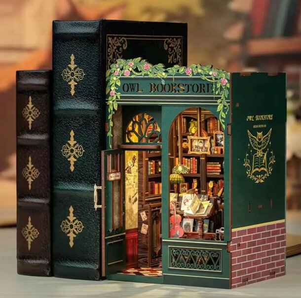 A cozy miniature bookstore featuring a bookcase and an open book on a table, inviting readers to explore.