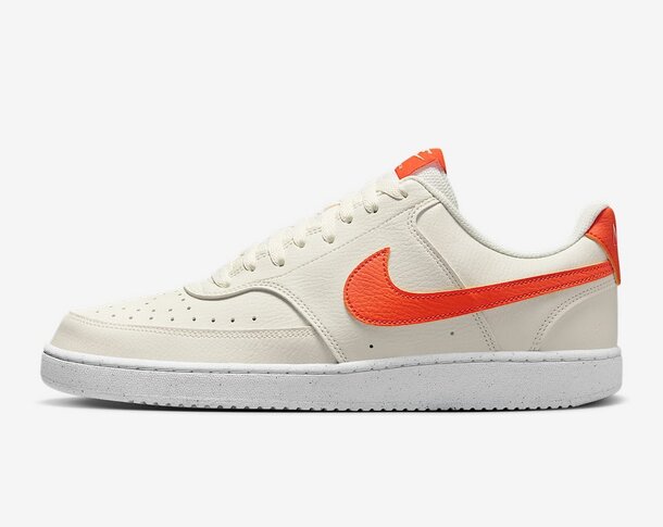 White Nike Air Force 1 Low shoes with vibrant orange details, showcasing a timeless and stylish sneaker silhouette.