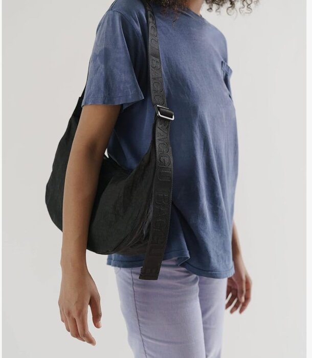 A black canvas bag displayed against a neutral background, showcasing its sturdy material and simple design.