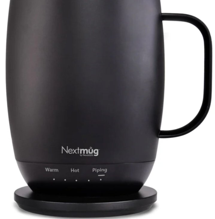 A sleek black electric mug with a subtle curve and handle, labeled "Nextmug." It rests on a base with temperature settings: Warm, Hot, Piping.