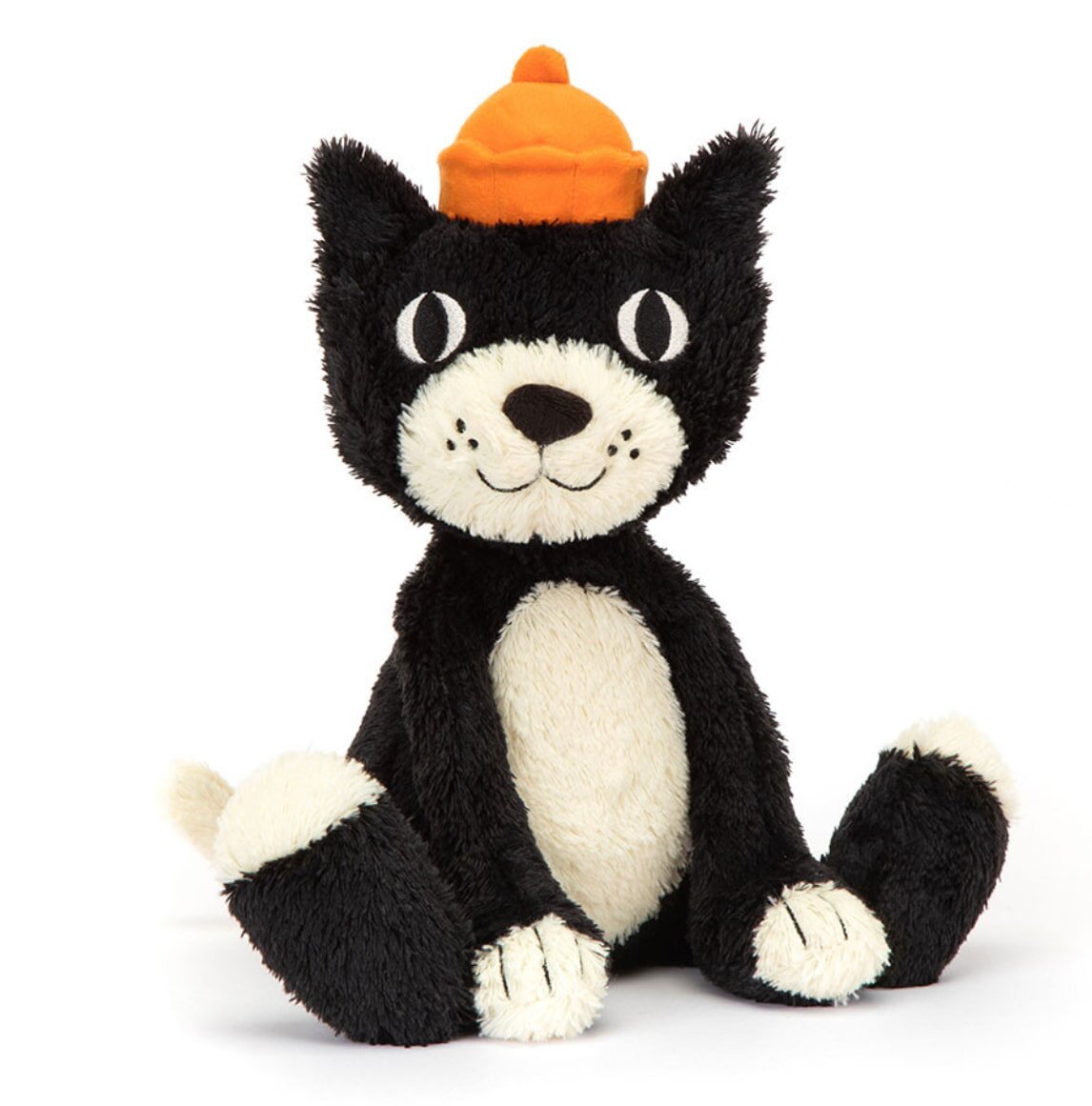 A black and white stuffed cat wearing an orange hat, sitting upright against a plain background.