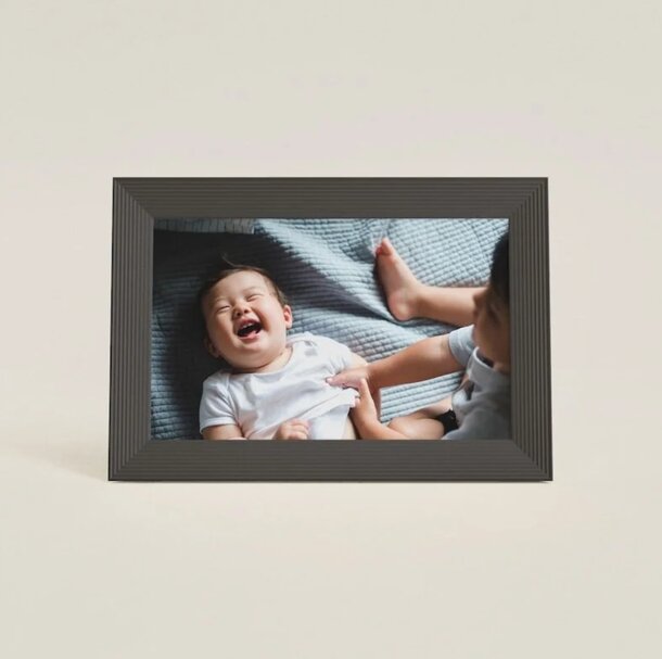 A joyful baby laughing, captured in a black-framed image, radiating happiness and innocence.