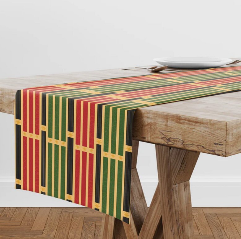 A table adorned with a vibrant red, green, and yellow table runner, enhancing the dining setting's visual appeal.