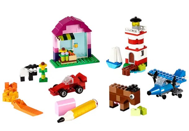 Colorful LEGO Friends set featuring a house, car, boat, and various toys arranged playfully on a surface.