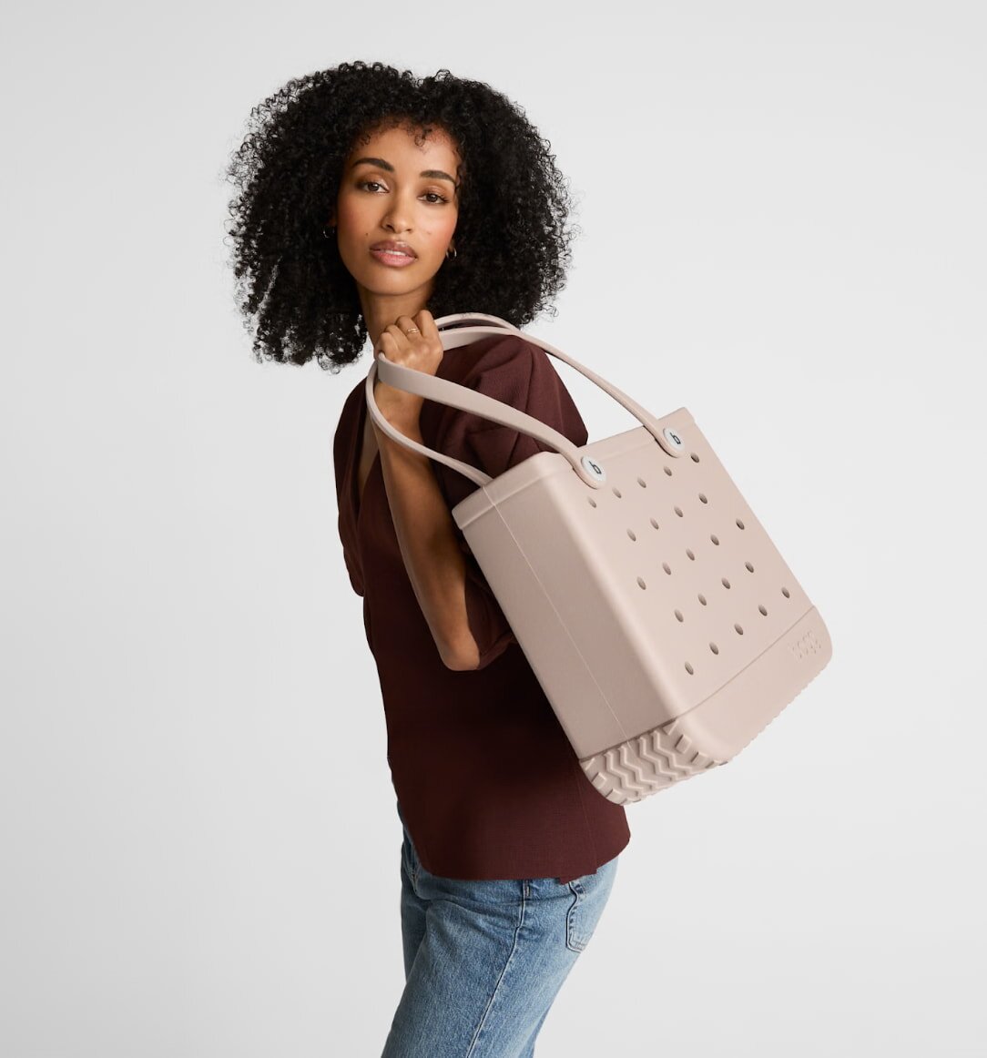 Beige tote bag displayed against a neutral background, showcasing its simple and elegant design.