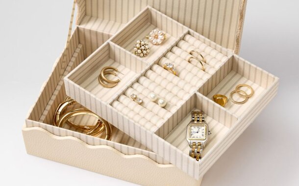 A jewelry box filled with various pieces of jewelry and watches, showcasing an elegant assortment of accessories.