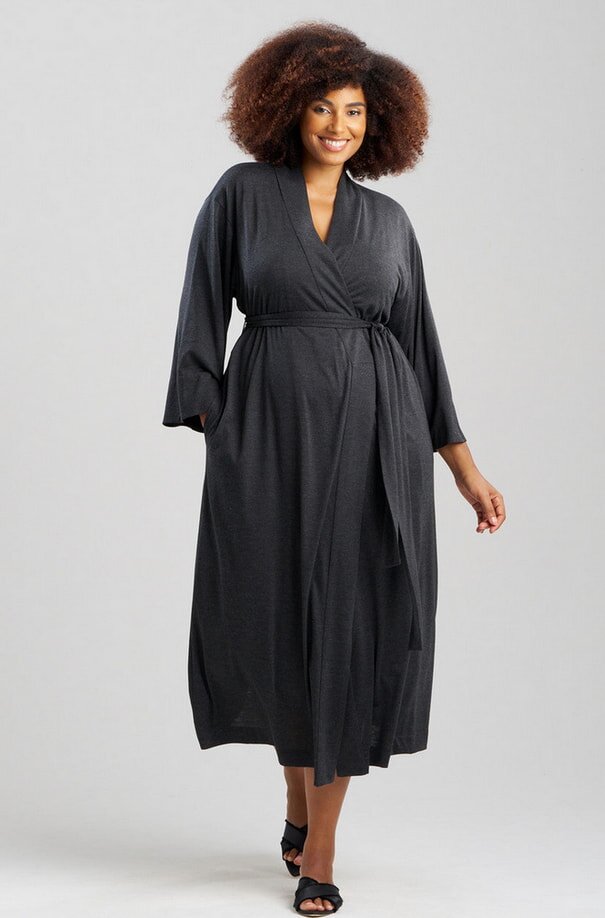 A woman in a black robe poses for a photo, smiling confidently at the camera.