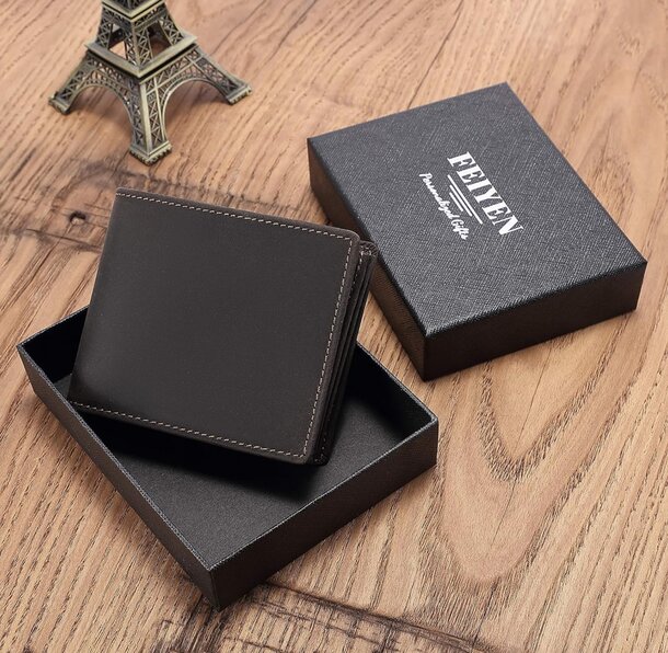 A black wallet in the foreground with a small Eiffel Tower visible in the blurred background.