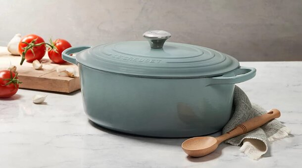 A vibrant Le Creuset Dutch oven in a rich color, showcasing its iconic design and sturdy handles for cooking versatility.