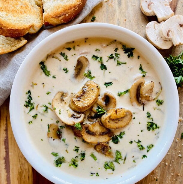 Creamy mushroom soup served in a white bowl, showcasing a smooth texture and rich color.