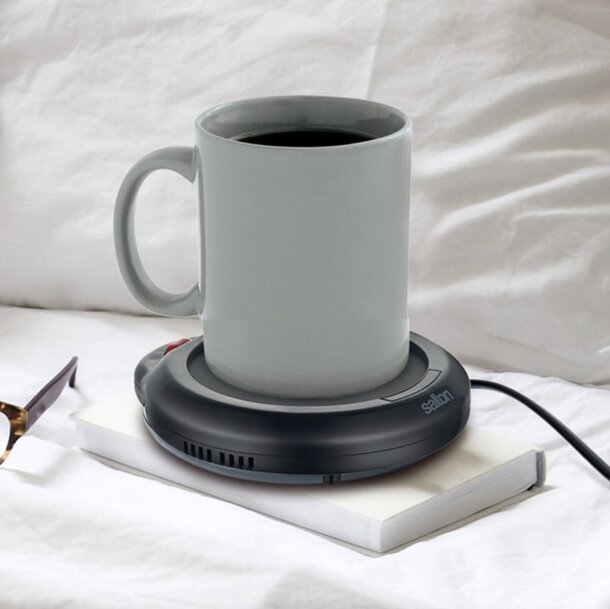 A ceramic mug placed on a sleek wireless charger, showcasing modern technology and design.
