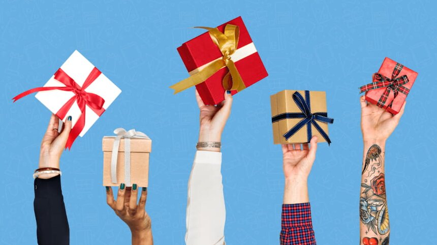 Multiple hands lift colorful gift boxes against a vibrant blue background, symbolizing celebration and generosity.