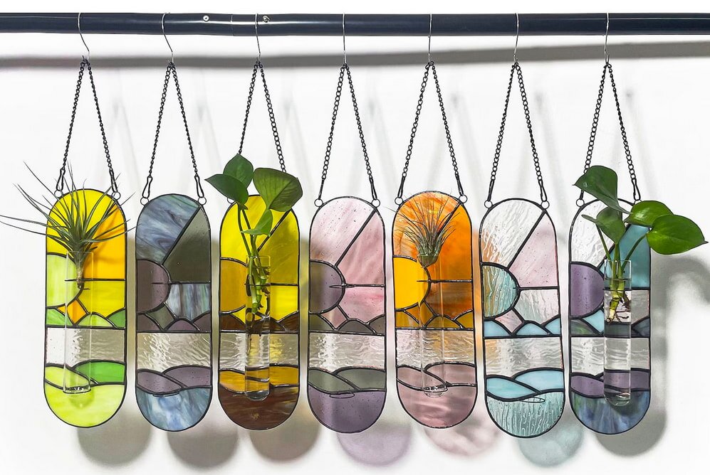 A collection of vibrant glass skateboards displayed artistically on a wall, showcasing various colors and designs.