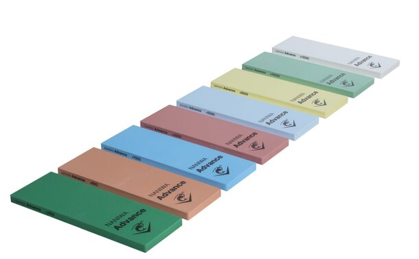A collection of six colored sandpaper blocks arranged together, showcasing various grits for sanding surfaces.