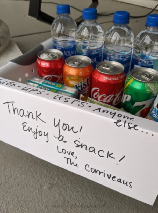 A box filled with bottled water and soda cans, labeled for postal and delivery workers with a note saying, "Thank you! Enjoy a snack! Love, The Corriveaus."