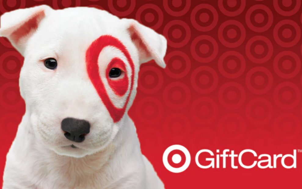 A white dog with a red target circle around its eye is on a red background with circular patterns. The word “GiftCard” and a target logo are on the right.