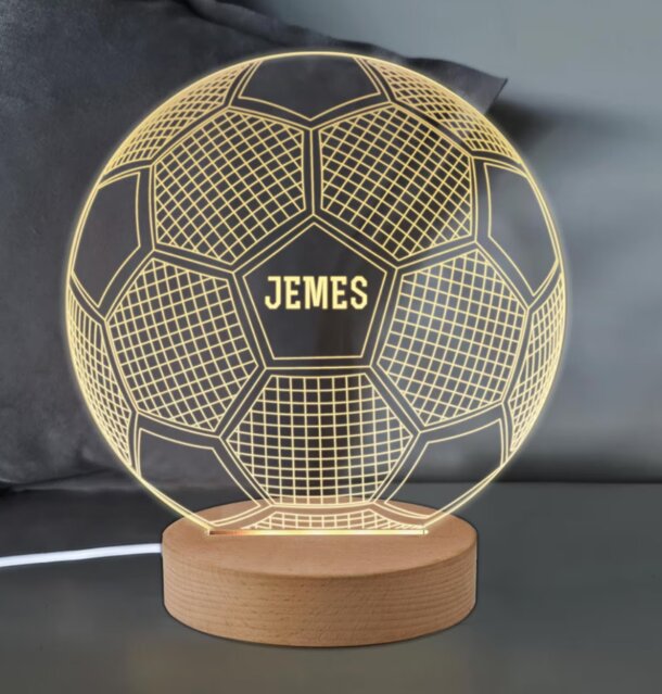 A personalized 3D LED lamp shaped like a football, glowing softly in various colors against a dark background.