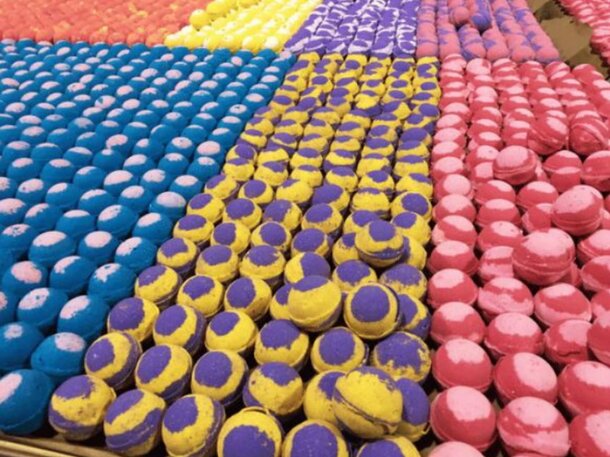 A box overflowing with an array of colorful bath bombs, showcasing different hues and designs.
