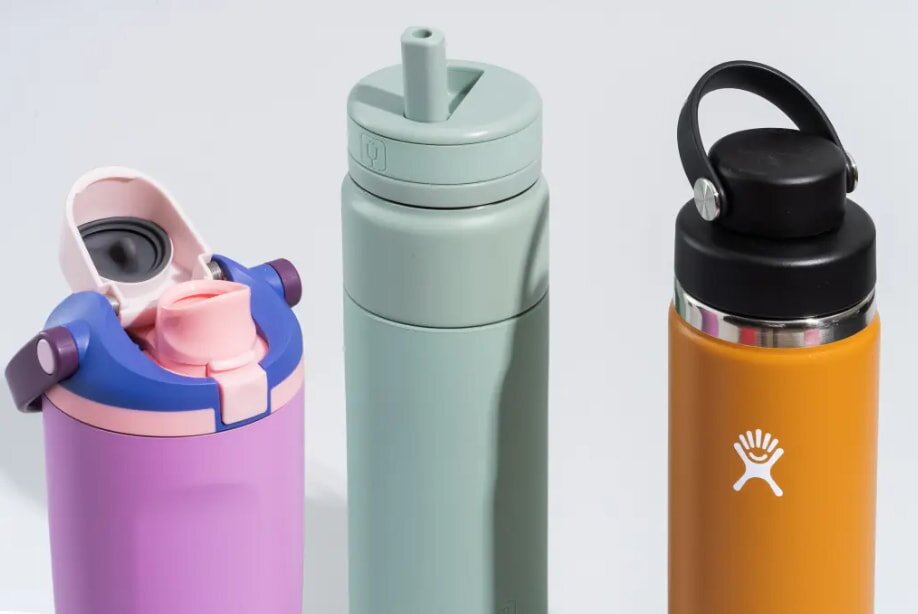 Three reusable insulated water bottles in purple, green, and orange