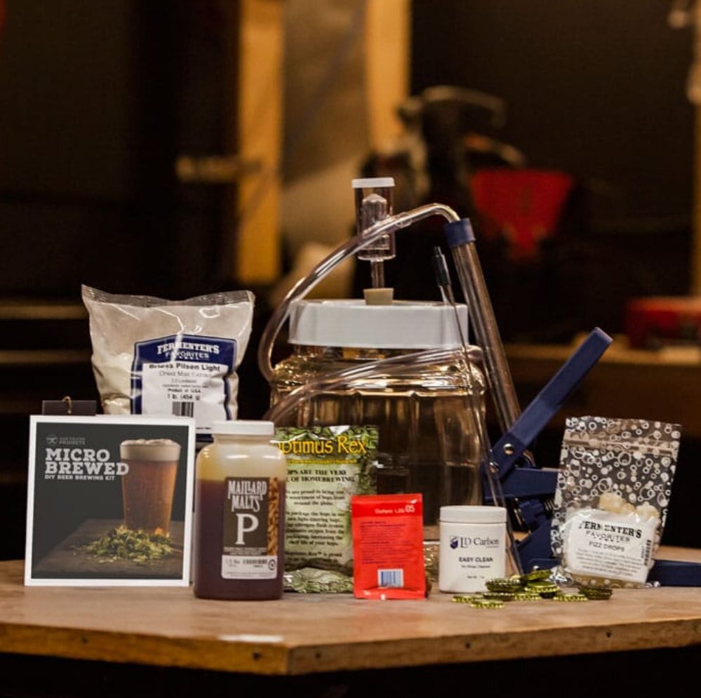 Beer brewing kit featuring a glass carboy for fermentation and brewing processes. 