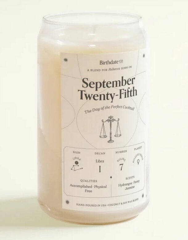 A lit candle with the date September 25th inscribed on it, symbolizing a special occasion or remembrance.