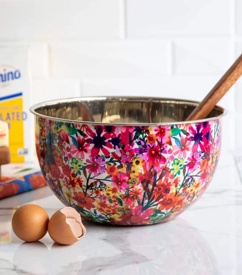  A vibrant mixing bowl filled with eggs and a wooden spoon resting inside, ready for baking or cooking.
