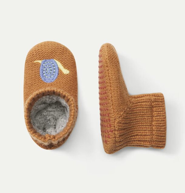 A pair of baby slippers featuring a charming blue and white design, perfect for little feet.