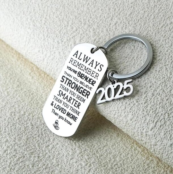 Inspirational keychain with the message "Always be a better person" displayed prominently on a sleek metal surface.