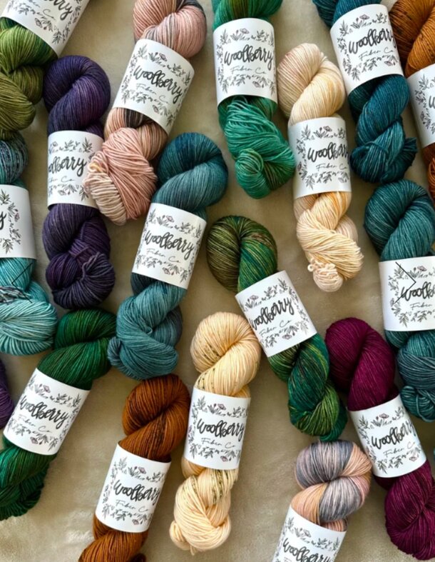 A collection of colorful yarns displayed with labels indicating their types and colors.