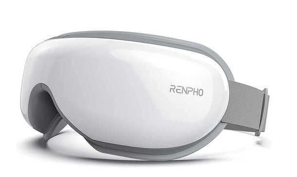 White and gray ski goggles resting on a flat surface, showcasing their sleek design and tinted lenses.