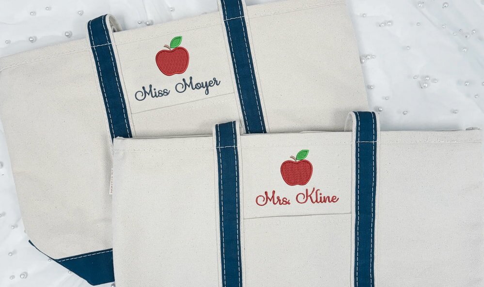 Two personalized canvas tote bags with apple designs