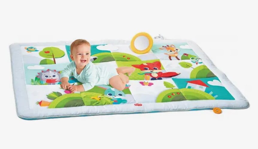 Baby lying on playmat with cartoon animals