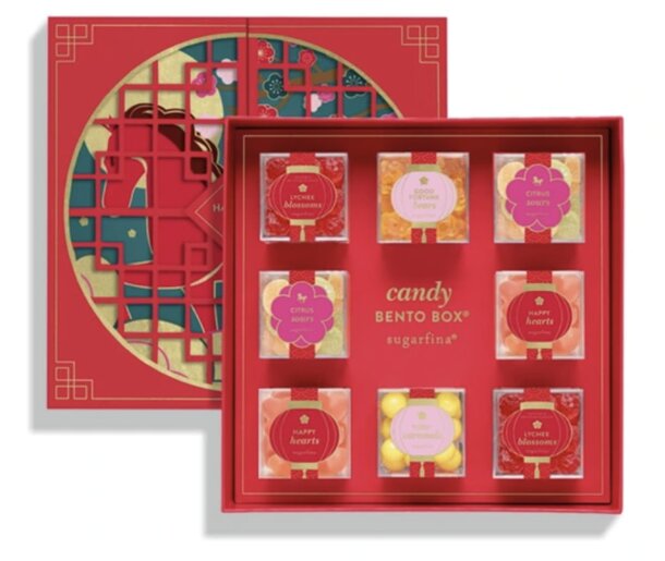 Red candy box with a horse design, featuring a grid of eight clear boxes filled with colorful candies. Labels include "Lychee Blossoms" and "Happy Hearts."