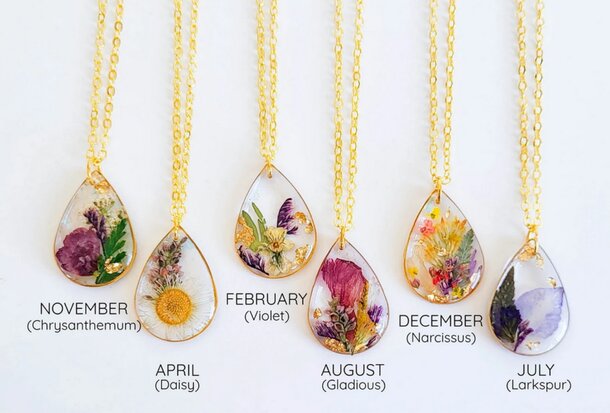 A collection of six flower types elegantly displayed on gold chains, showcasing their vibrant colors and unique shapes.