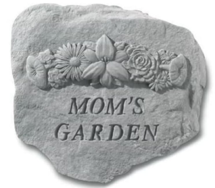 Stone garden plaque with carved flowers and the inscription "Mom's Garden." The design conveys warmth and a personal touch, celebrating a cherished space.