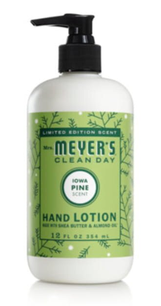 Mrs. Meyer's hand lotion bottle with a floral design, placed on a wooden surface, showcasing its natural ingredients.