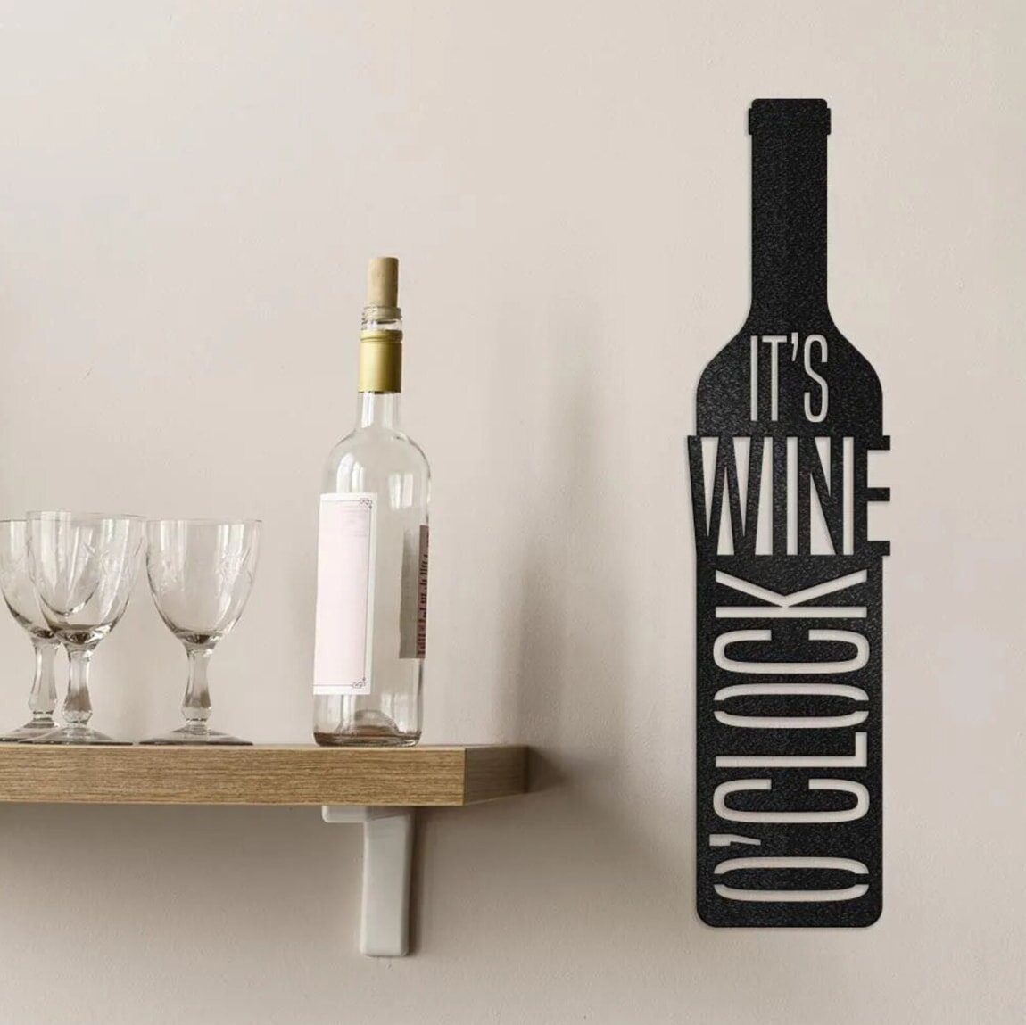 A wine bottle and glass elegantly displayed on a wooden shelf, showcasing a refined atmosphere.