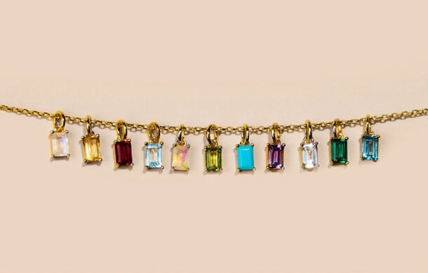 A gold chain adorned with an array of colorful stones, showcasing a vibrant and elegant design.